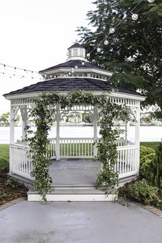 a white gazebo surrounded by greenery and lights