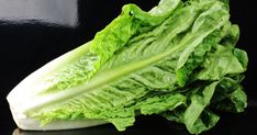 lettuce on a black surface with one leaf still attached to the other end