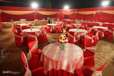 tables and chairs covered in red cloths with flowers on them