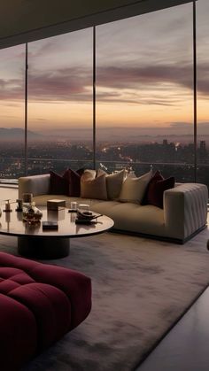 a living room filled with furniture and large windows overlooking the city at sunset or dawn