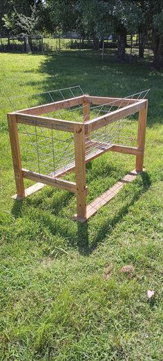 a wooden bed frame sitting in the grass