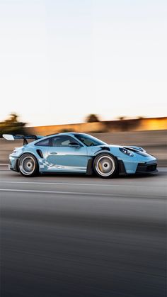 a blue sports car driving down the road