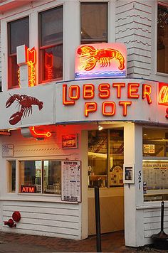 the lobster pot restaurant is lit up in red and yellow neon lights on the building