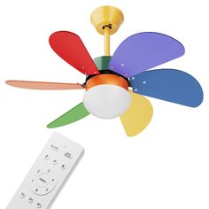 a multicolored ceiling fan with a remote control in front of it and a white background