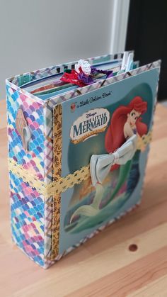 the little mermaid book is sitting on a table