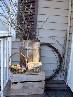 an old wooden crate with eggs in it sitting on a porch next to a planter