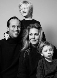 a man, woman and two children are posing for a black and white photo together