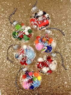 christmas baubles with writing on them are sitting on the floor next to some candy