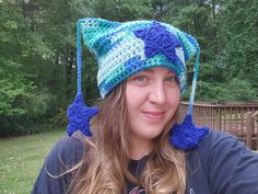 a woman wearing a crocheted hat with blue and white stars on the brim