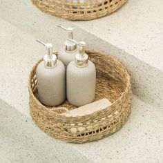 two soap dispensers sitting in a basket on the steps next to each other