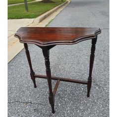 a wooden table sitting on the side of a road