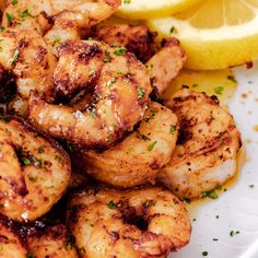 grilled shrimp on a plate with lemon wedges