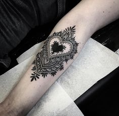 a black and white heart tattoo on the arm