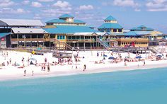 the beach is crowded with people and umbrellas on a sunny day at the resort