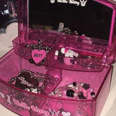 a pink vanity with hello kitty jewelry in it