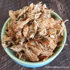 shredded chicken in a blue bowl on a wooden table