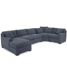 a large sectional couch with pillows on the back and arms, in dark green fabric