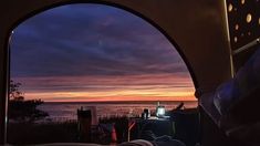 the view from inside an rv looking out at the ocean and sunset over the water