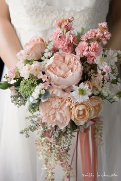 a bridal holding a bouquet of pink and white flowers