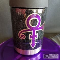 a purple and black cup sitting on top of a purple table