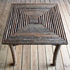 a wooden bench made out of sticks on a wood floor