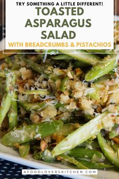 a white plate topped with asparagus and breadcrumbs