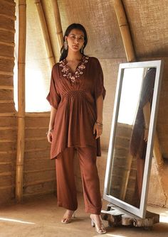 Crafted out of modal fabric, this dress incorporates honeycomb smocking delicately tucked in a chic kaftan silhouette. This is paired with straight pants and comes as a set of 2. Fabric : Modal Satin Colour : Brown Embroidery details : Hand embroidery No.of components : 2 Delivery time : 15-20 days Washing Instructions : DRY CLEAN ONLY Honeycomb Smocking, Kaftan Sleeves, V Neck Kaftan, Plazo Set, Embroidered Kaftan, Simple Pakistani Dresses, Designer Dresses Casual, Cycling Fashion, Satin Color