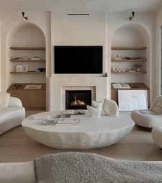 a living room filled with furniture and a flat screen tv mounted on the wall above a fire place