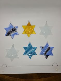 six star shaped glass ornaments hanging on a wall