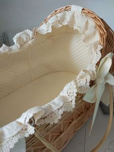 an empty wicker basket with white lace on the bottom and ribbon around the edge