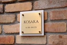 a plaque mounted to the side of a brick wall that reads kosaka 4 - 10 - 19