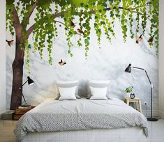 a bedroom with a tree mural on the wall