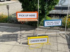 there are two signs that say pick up here and order here on the same sign