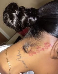 the back of a woman's head with tattoos on it