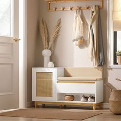 an entryway with a bench, coat rack and baskets