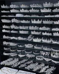 a display case filled with lots of white tiaras and necklaces on glass shelves