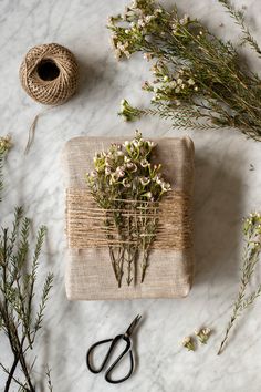 a bunch of flowers sitting on top of a table next to twine spools