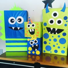 three paper bags with monsters on them are sitting on a shelf next to each other