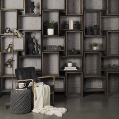 an empty chair in front of a bookshelf with many shelves on the wall