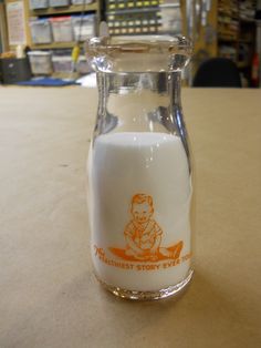 a glass bottle filled with milk sitting on top of a table