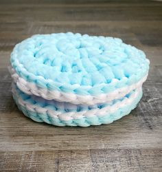 three blue and white coasters sitting on top of a wooden table