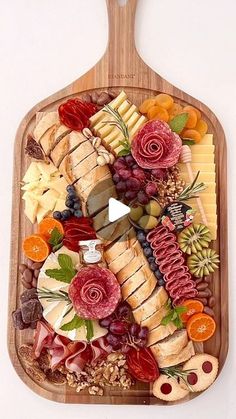 a wooden platter filled with different types of cheese and meats