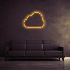 a couch sitting in front of a wall with a neon cloud on it's side