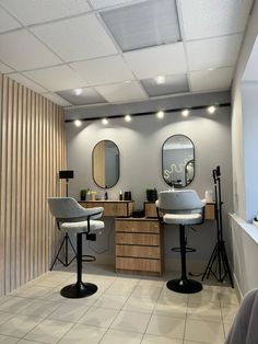 a salon with two chairs and mirrors on the wall