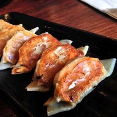 some food is sitting on a black tray and ready to be eaten by someone else