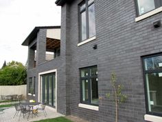 an outside view of a house with tables and chairs