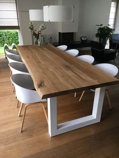 a large wooden table surrounded by white chairs