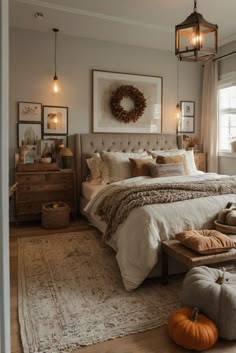 a bedroom decorated in neutral tones with pumpkins on the floor and lights hanging from the ceiling