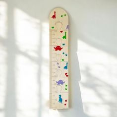 a white ruler with colorful drawings on it hanging from the wall next to a window