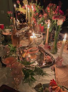 a table is set with candles, flowers and wine glasses for an elegant dinner party